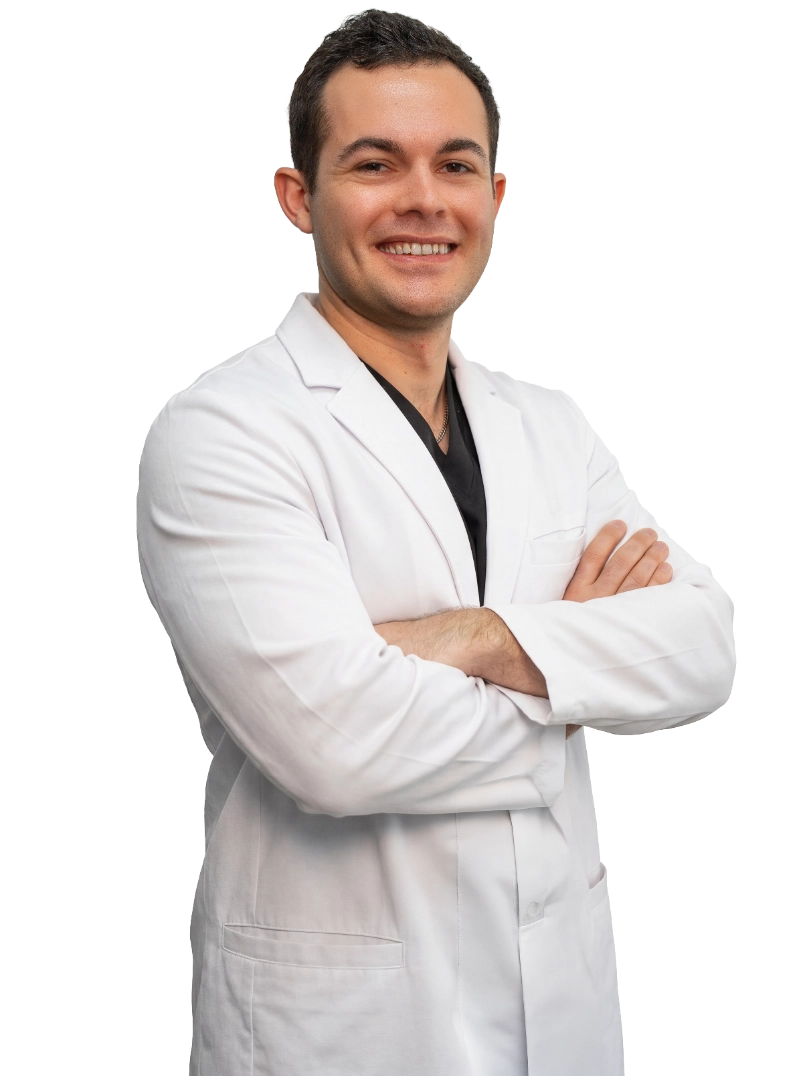 A friendly doctor in a white lab coat shows information about a vein treatment process on a tablet to a seated, smiling patient in a modern medical office setting.